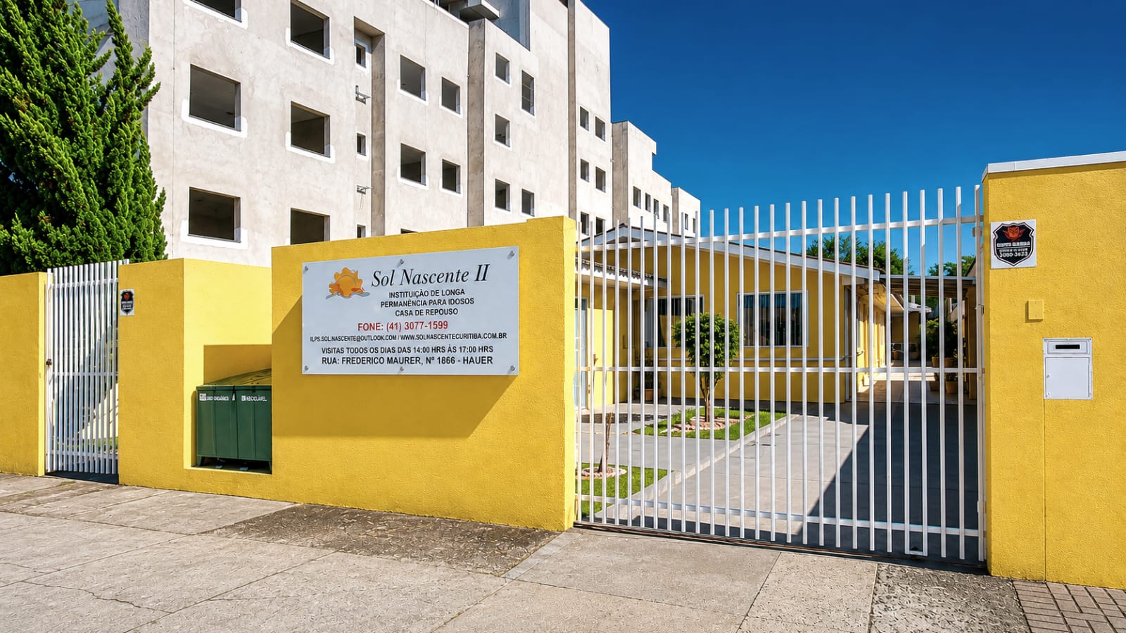 Fachada amarela da Casa Sol Nascente com portão de entrada